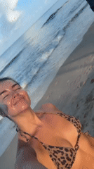 Woman photographs herself on Thai beach at sunrise