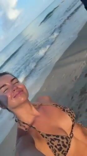 Woman photographs herself on Thai beach at sunrise