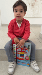 Toddler reads firefighter sound book in Luxembourg home Friday morning