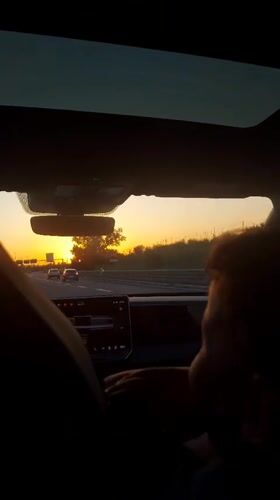 Driver silhouetted against sunset on Rome highway