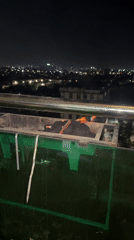 Balcony barbecue session overlooks Tashkent city lights at evening