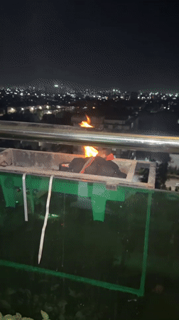 Balcony barbecue session overlooks Tashkent city lights at evening