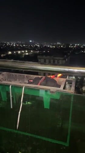 Balcony barbecue session overlooks Tashkent city lights at evening