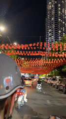 Nha Trang streets bustling with motorbikes under red flag decorations