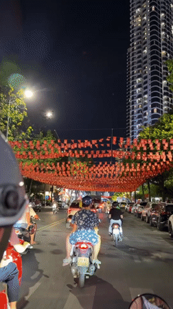 Nha Trang streets bustling with motorbikes under red flag decorations