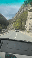 Driver navigates mountain road in Bulgaria under overcast skies