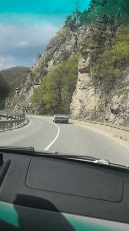 Driver navigates mountain road in Bulgaria under overcast skies