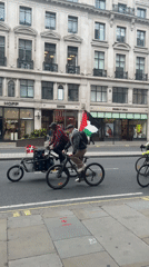 Cyclists carry Palestinian flags through central London streets