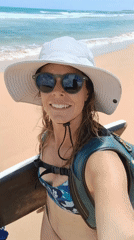 Woman films beach selfie with boogie board in Luquillo