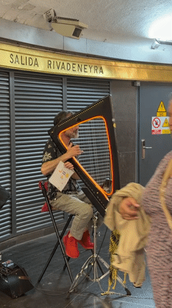 Harpist performs in Barcelona subway station during evening rush