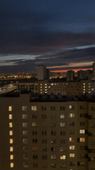Evening cityscape captured showing lit apartments, glowing skyline