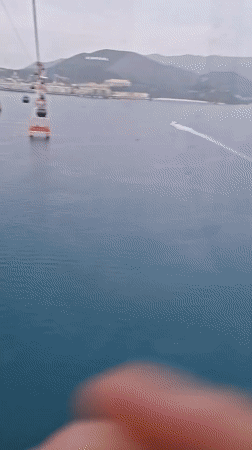 Cable car passenger films ocean views in Nha Trang