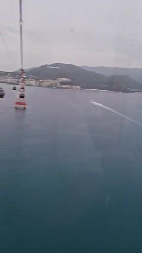 Cable car passenger films ocean views in Nha Trang