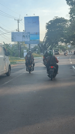 Motorbike rider captures street traffic in Blahbatuh, Bali
