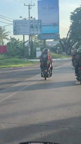Motorbike rider captures street traffic in Blahbatuh, Bali