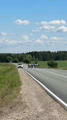 Cycling group rides rural road near Niva, Russia