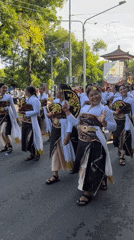 Traditional Balinese procession with costumed participants in Denpasar
