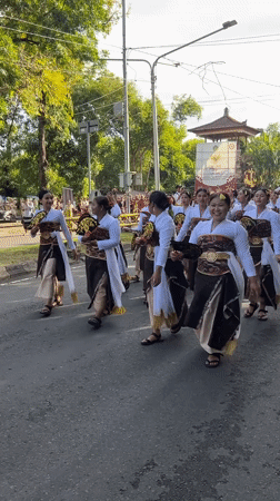 Traditional Balinese procession with costumed participants in Denpasar