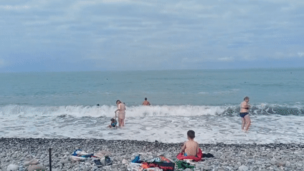 Morning beach scene in Sochi with swimmers and sunbathers