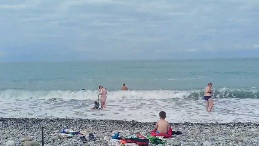 Morning beach scene in Sochi with swimmers and sunbathers