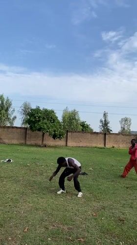 Two men perform backflips, acrobatics on lawn in Vom