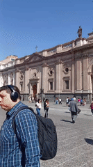 Pedestrians gather at ornate cathedral in Santiago city square