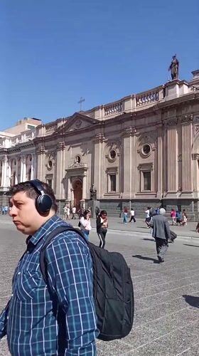Pedestrians gather at ornate cathedral in Santiago city square