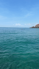 Boat approaches hilly island in calm Vietnamese waters