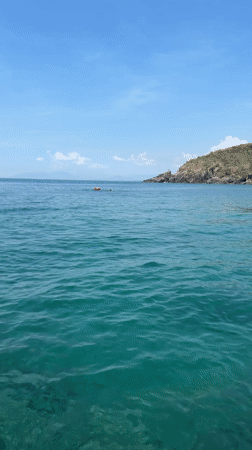 Boat approaches hilly island in calm Vietnamese waters