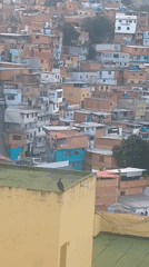 Caracas hillside barrios at dusk, rooftops and stormy sky