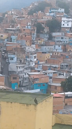 Caracas hillside barrios at dusk, rooftops and stormy sky