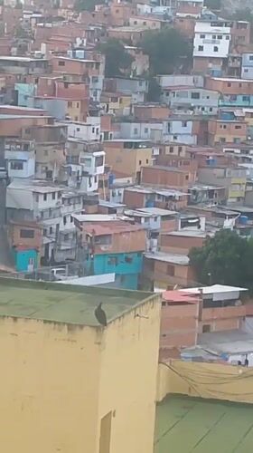Caracas hillside barrios at dusk, rooftops and stormy sky