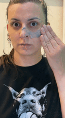 Woman applies product in bathroom wearing dog t-shirt