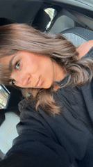 Woman poses in car driver's seat in Antibes