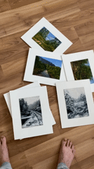 Artist displays miniature landscape paintings on wooden floor in Bílina