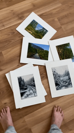 Artist displays miniature landscape paintings on wooden floor in Bílina