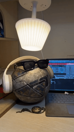 Soccer ball with headphones and sunglasses spotted on desk