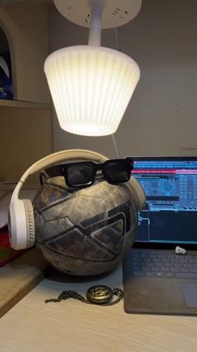 Soccer ball with headphones and sunglasses spotted on desk