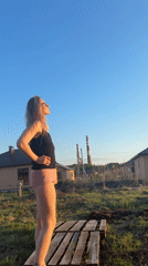 Woman observed stargazing from wooden pallet in Russian yard
