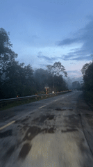 Car travels foggy mountain road near Huế, Vietnam