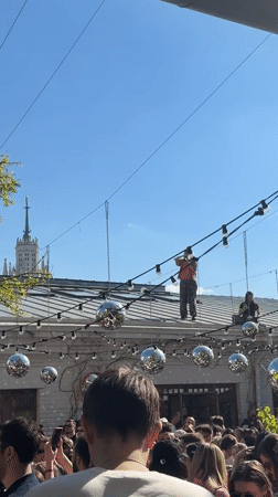 Crowd gathers at decorated outdoor venue for daytime event