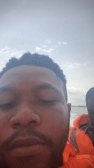 Group takes boat trip with life vests under cloudy skies