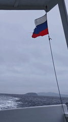 Boat underway near Reineke Island, Russian flag flying
