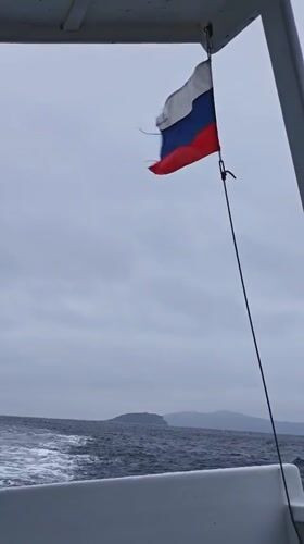 Boat underway near Reineke Island, Russian flag flying