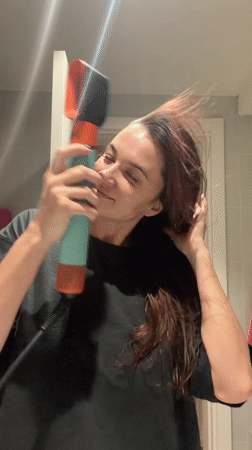 Woman dries hair with Dyson dryer in Belgrade bathroom