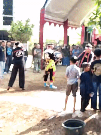 Traditional masked performance with costumes and props in Sumberejo
