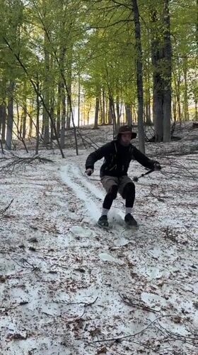 Man slides down snowy slope in Russian forest