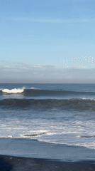 Ocean waves break on dark beach in Kediri