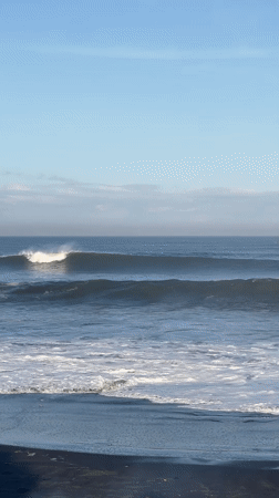 Ocean waves break on dark beach in Kediri