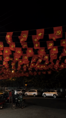 Red flags with yellow symbols displayed across Nam Nha Trang Ward